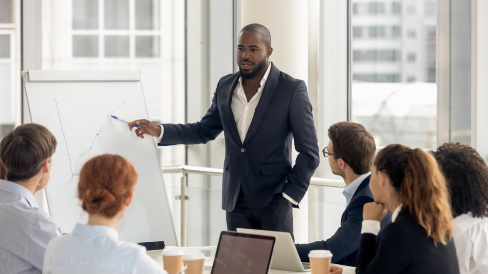 An executive coach giving a lecture to a group of employees